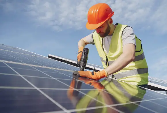 Homem instalando painel solar no teto de uma empresa